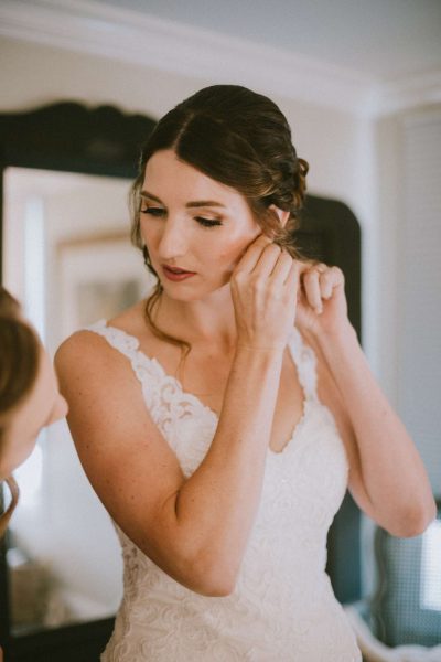 Bride puts her earring on-Image by Anna Gutermuth Photography