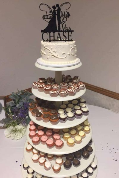 Cupcake tower with single tier wedding cake and bride and groom topper