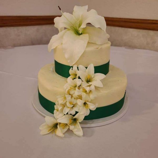 Two tiered wedding cake with magnolia arrangement trim