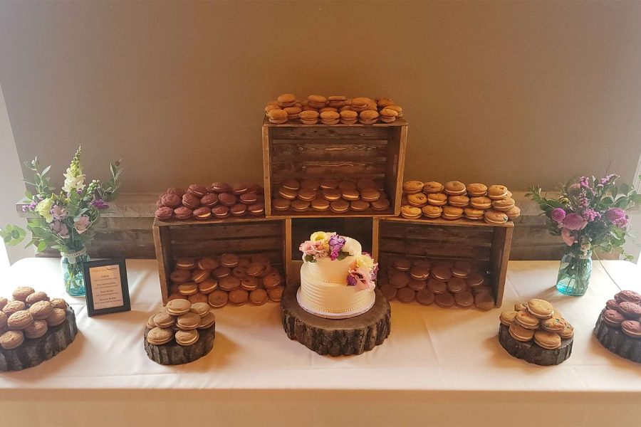 Dessert table with small wedding cake and gourmet sandwich cookies.