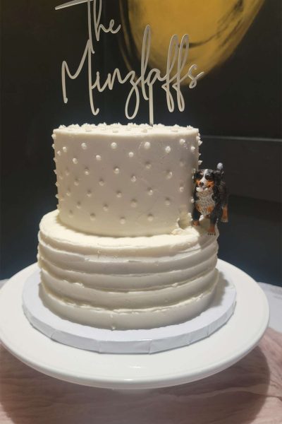 Elegant 2 tiered white wedding cake with dog.