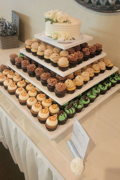 Tower of cupcakes with white wedding cake at top from the Cupcake Couture.